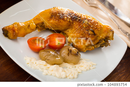 Fried chicken legs with baked onions and sauce 104893754