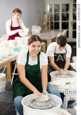 Young woman sculpting product on potter's wheel 104893979