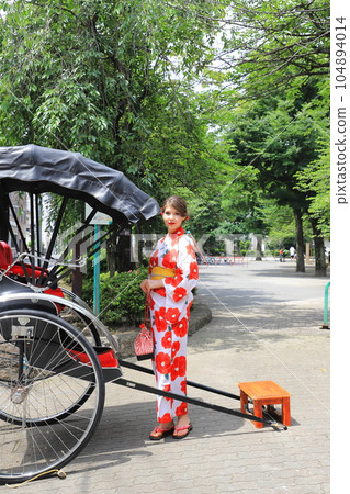 A rickshaw and a foreign woman in a kimono A rickshaw and a foreign woman in a kimono 104894014