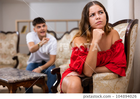 Disgruntled young husband swears at his wife Disgruntled young husband swears at his wife 104894026