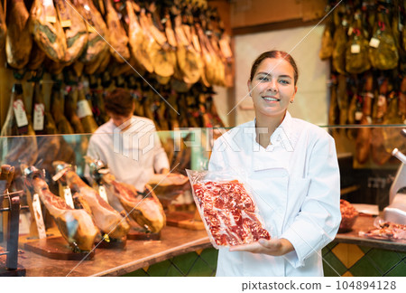 Portrait of young woman jamoneria worker with pack of ham Portrait of young woman jamoneria worker with pack of ham 104894128