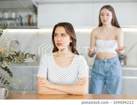Two young women quarrel in kitchen at home 104894222