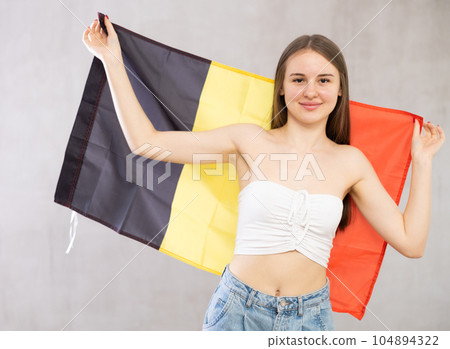 Portrait of happy young woman of Belgium match waving national flag 104894322