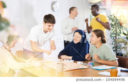 Group of multinational people playing board game Group of multinational people playing board game 104894496