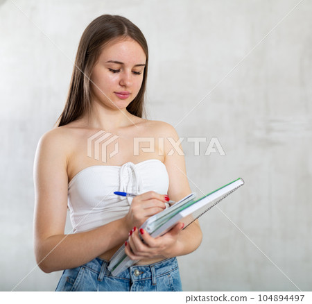 Smiling happy girl student hold books on gray background studio portrait. Education in high school university college concept Smiling happy girl student hold books on gray background studio portrait. Education in high school university college concept 104894497