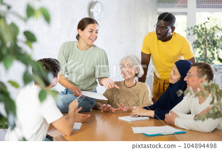 Interested girl student discussing with group of coursemates 104894498