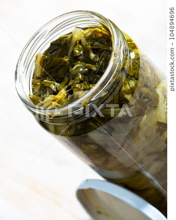 Glass jar with pickled swiss chard 104894696