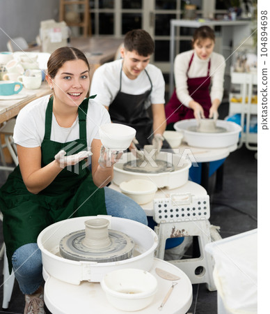 Young woman holding crafted clay cup 104894698