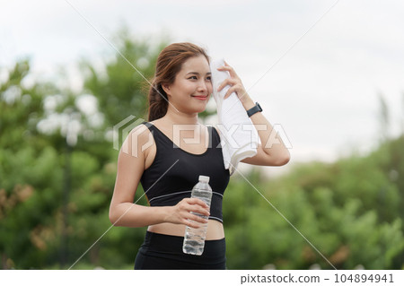 Healthy Asian woman is warm up before jogging. Fitness girl running. Female exercising at outdoor park 104894941