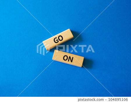 Go on symbol. Wooden blocks with words Go on. Beautiful blue background. Business and Go on concept. Copy space. Go on symbol. Wooden blocks with words Go on. Beautiful blue background. Business and Go on concept. Copy space. 104895106
