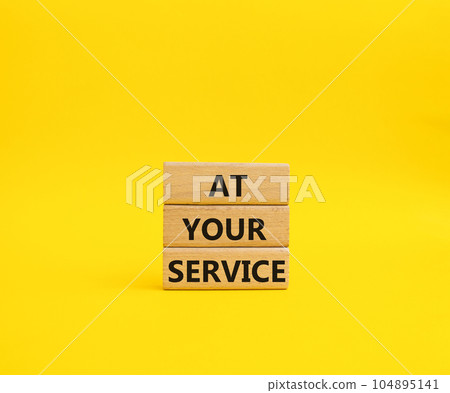 At your service symbol. Wooden blocks with words At your service. Beautiful yellow background. Business and At your service concept. Copy space. At your service symbol. Wooden blocks with words At your service. Beautiful yellow background. Business and At your service concept. Copy space. 104895141