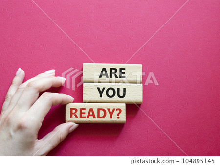 Are you ready symbol. Concept word Are you ready on wooden blocks. Businessman hand. Beautiful red background. Business and Are you ready concept. Copy space 104895145