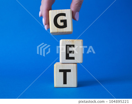 GET symbol. Concept word GET on wooden cubes. Businessman hand. Beautiful blue background. Business and GET concept. Copy space. 104895221