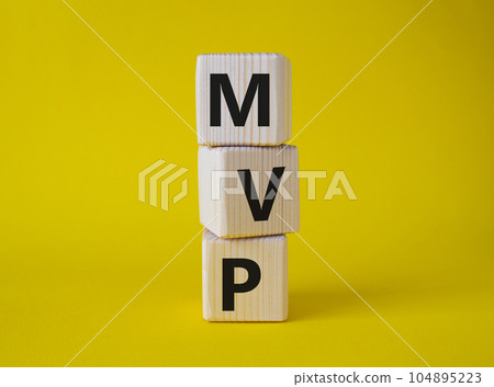 MVP - Most Valuable Player symbol. Wooden cubes with words MVP. Beautiful yellow background. Business and MVP concept. Copy space. 104895223