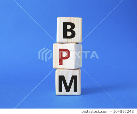 BPM - Business Process Management symbol. Wooden cubes with words BPM. Beautiful blue background. Business and BPM concept. Copy space. 104895248