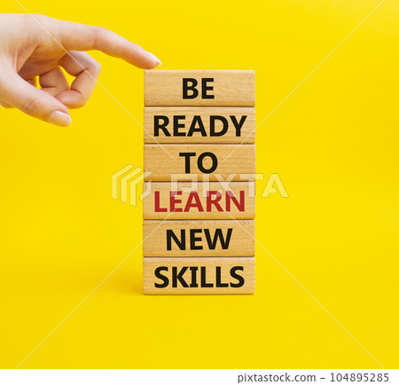 Learn new skills symbol. Concept words Be ready to Learn new skills on wooden blocks. Beautiful yellow background. Businessman hand. Business and Learn new skills concept. Copy space. 104895285