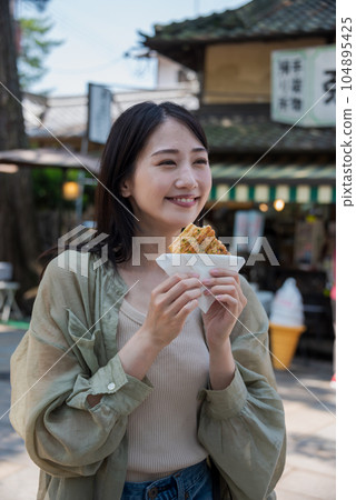 plain clothes woman eating okaki 104895425