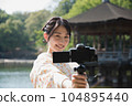 Kimono woman taking a V-log selfie at a tourist spot 104895440