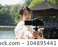 Kimono woman taking a V-log selfie at a tourist spot 104895441