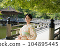 A smiling kimono woman standing in a fresh green tourist spot 104895445