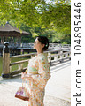 A kimono woman standing in a fresh green tourist spot 104895446
