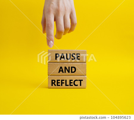 Pause and Reflect symbol. Concept words Pause and Reflect on wooden blocks. Beautiful yellow background. Businessman hand. Business and Pause and Reflect concept. Copy space. Pause and Reflect symbol. Concept words Pause and Reflect on wooden blocks. Beautiful yellow background. Businessman hand. Business and Pause and Reflect concept. Copy space. 104895623