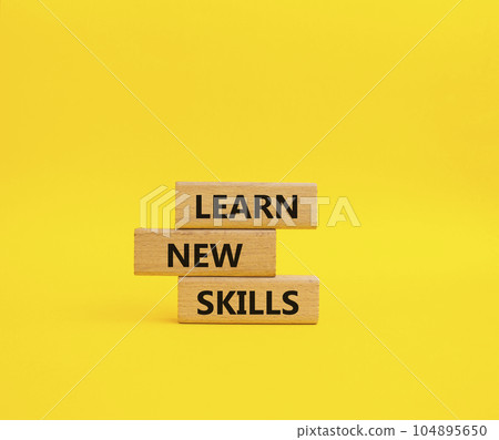 Learn new skills symbol. Concept words Learn new skills on wooden blocks. Beautiful yellow background. Business and Learn new skills concept. Copy space. 104895650