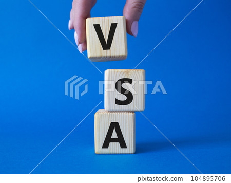 VSA - Volume Spread Analysis symbol. Wooden cubes with word VSA. Businessman hand. Beautiful blue background. Business and Volume Spread Analysis concept. Copy space. 104895706