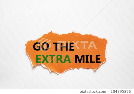 Go the extra mile symbol. Torn orange paper with words Go the extra mile. Beautiful white background. Business and Go the extra mile concept. Copy space. 104895896