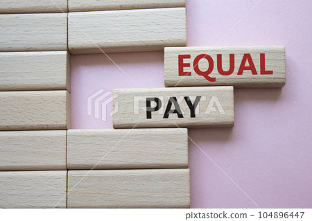 Equal Pay symbol. Wooden blocks with words Equal Pay. Beautiful pink background.Business and Equal Pay concept. Copy space. Equal Pay symbol. Wooden blocks with words Equal Pay. Beautiful pink background.Business and Equal Pay concept. Copy space. 104896447