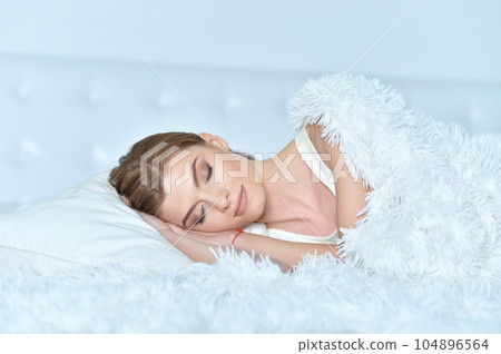 young woman lying on soft bed in the bedroom young woman lying on soft bed in the bedroom 104896564