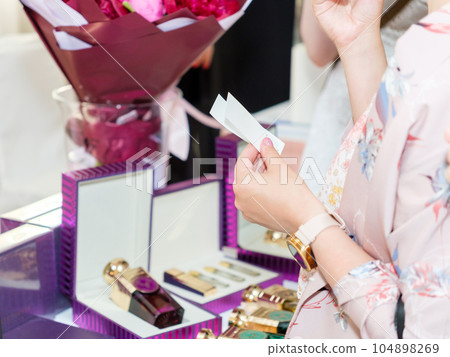 Perfume blotters in a female hand. Perfume blotters in a female hand. 104898269