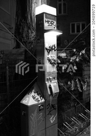 Vertical grayscale view of a dirty old public telephone booth in Hamburg Vertical grayscale view of a dirty old public telephone booth in Hamburg 104899719
