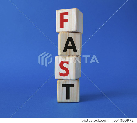 Fast symbol. Concept word Fast on wooden cubes. Beautiful blue background. Business and Fast concept. Copy space. Fast symbol. Concept word Fast on wooden cubes. Beautiful blue background. Business and Fast concept. Copy space. 104899972