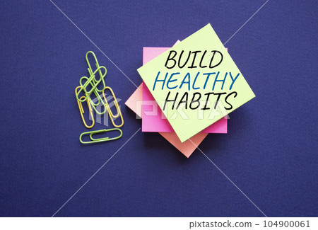 Healthy habits symbol. Concept word Build Healthy habits on yellow stealy note with paper clips. Beautiful deep blue background. Healthy lifestyle and Healthy habits concept. Copy space Healthy habits symbol. Concept word Build Healthy habits on yellow stealy note with paper clips. Beautiful deep blue background. Healthy lifestyle and Healthy habits concept. Copy space 104900061