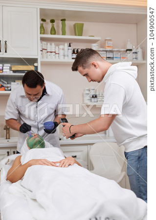 operator films the process of appling mask to the face of woman 104900547