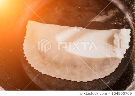 woman's hands making qutab or chebureki with a rolling pin and minced meat onion in dough for culinary concepts related to Azerbaijani, Tatar and Greek cuisine, as well as empanadas in Latin America. woman's hands making qutab or chebureki with a rolling pin and minced meat onion in dough for culinary concepts related to Azerbaijani, Tatar and Greek cuisine, as well as empanadas in Latin America. 104900769