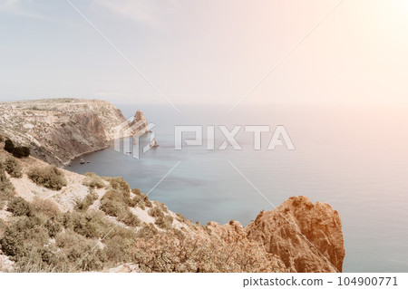 Aerial view from above on calm azure sea and volcanic rocky shores. Small waves on water surface in motion blur. Nature summer ocean sea beach background. Nobody. Holiday, vacation and travel concept 104900771