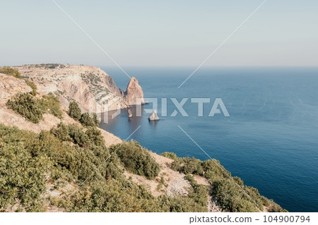 Aerial view from above on calm azure sea and volcanic rocky shores. Small waves on water surface in motion blur. Nature summer ocean sea beach background. Nobody. Holiday, vacation and travel concept 104900794