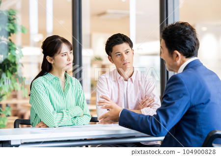 A young couple consulting a middle planner A young couple consulting a middle planner 104900828