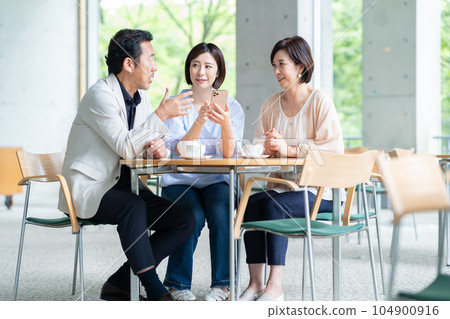 A family enjoying while operating a smartphone in a cafe 104900916