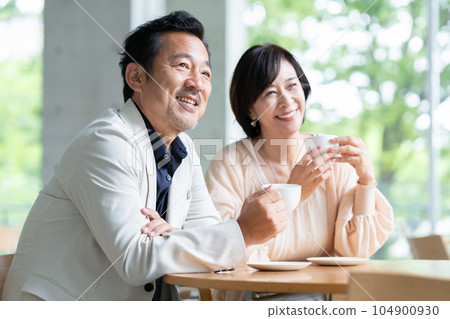 A couple drinking coffee and having a conversation in a cafe 104900930