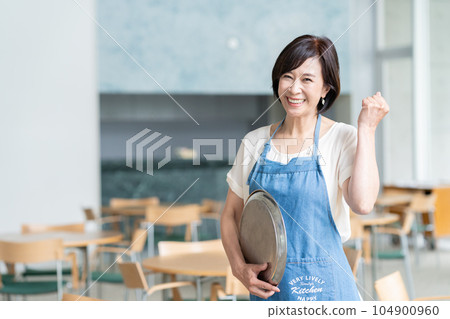 Middle-aged female clerk working in a cafe Middle-aged female clerk working in a cafe 104900960