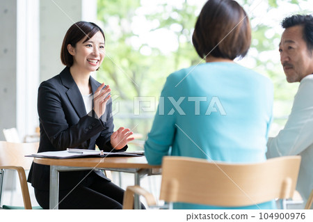 女商人在咖啡館與一對中年夫婦談生意 104900976
