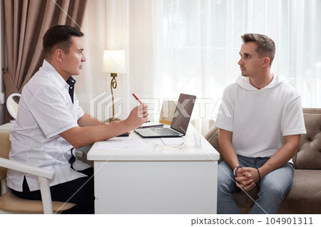 male Doctor talking to patient in office 104901311