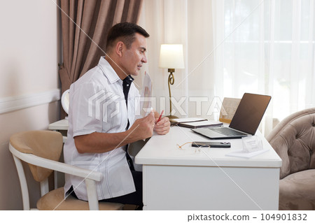 male doctor in white medical uniform using computer laptop male doctor in white medical uniform using computer laptop 104901832