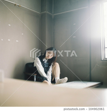 High school girl sitting with her legs on the desk High school girl sitting with her legs on the desk 104902061