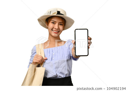 Young woman in summer hat and casual clothes, showing mobile phone in hand with empty screen 104902194