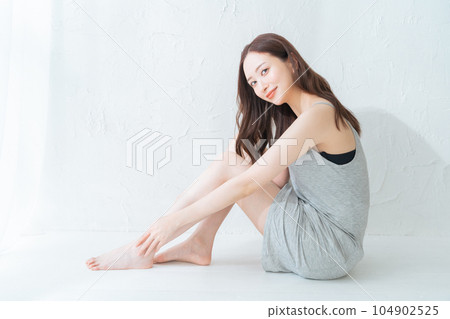 做腿部皮膚護理和按摩的年輕女性 做腿部皮膚護理和按摩的年輕女性 104902525