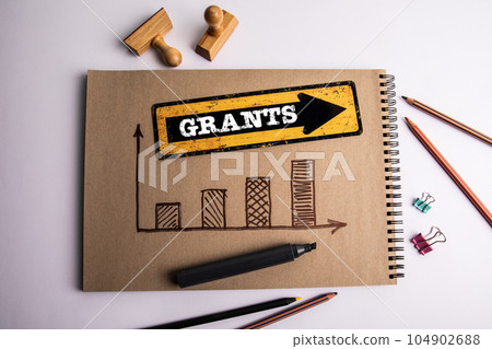 GRANTS. Text on the pointing arrow. Office items on white background 104902688